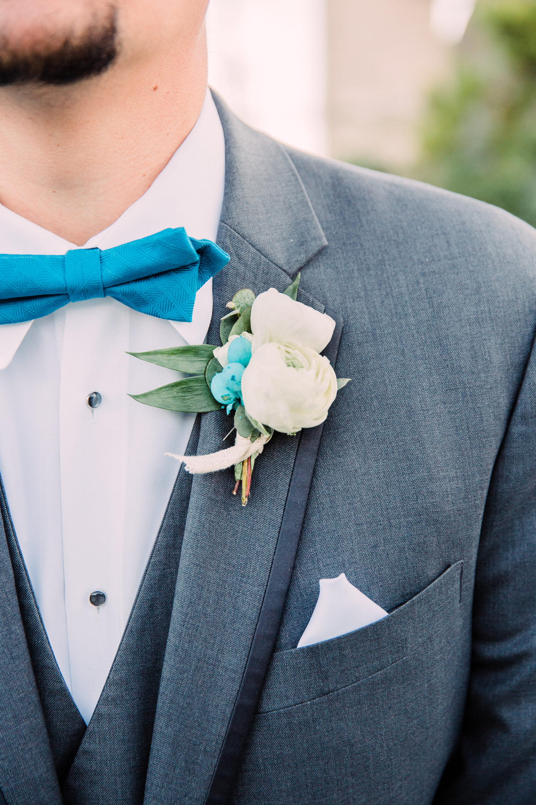 Adorable little blue bow tie with a beautifully complementing boutonnière. I simply adore the splash of matching blue underneath the white flowers.